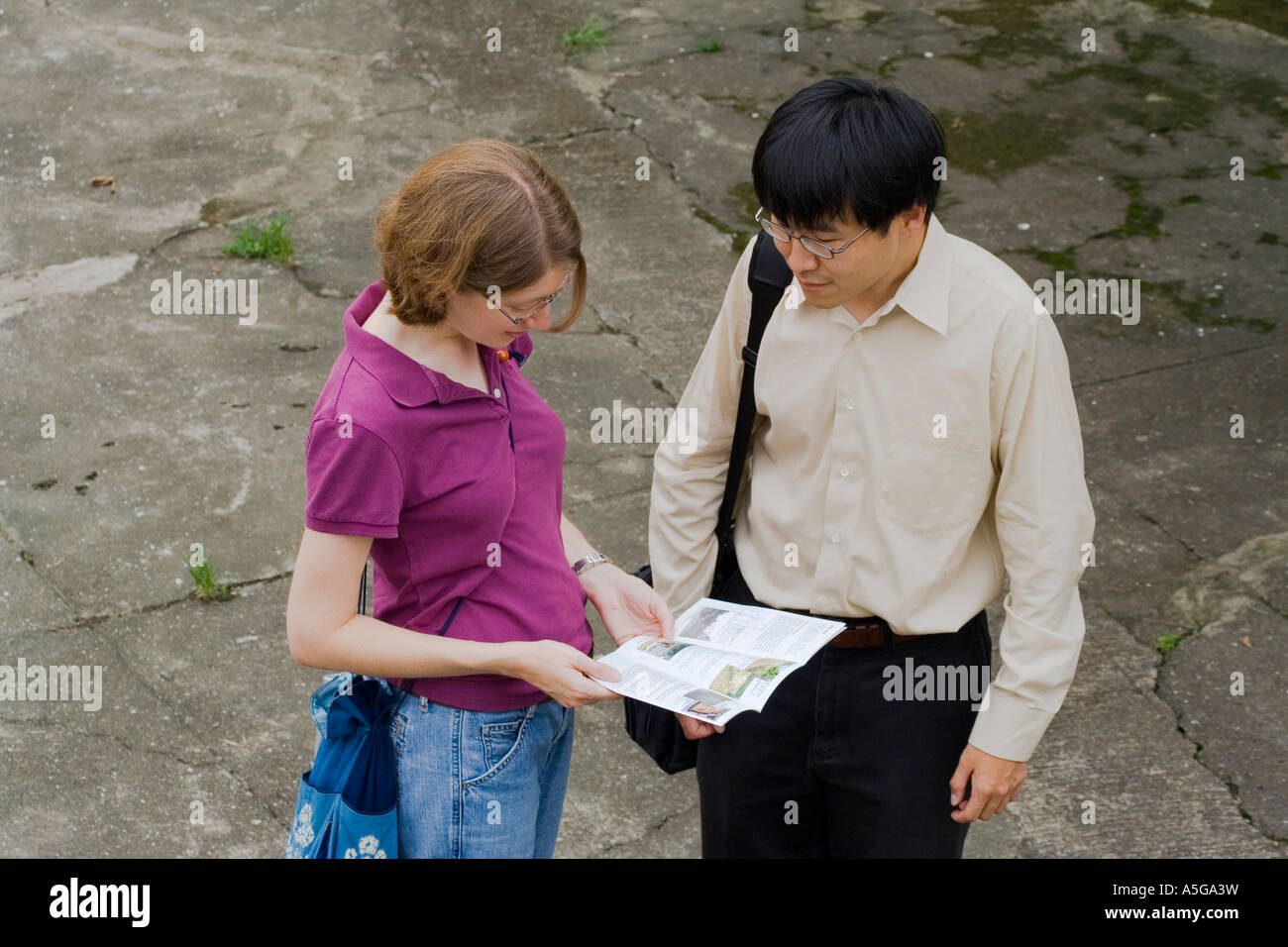 Young Asian Man et Woman regarder une brochure Banque D'Images