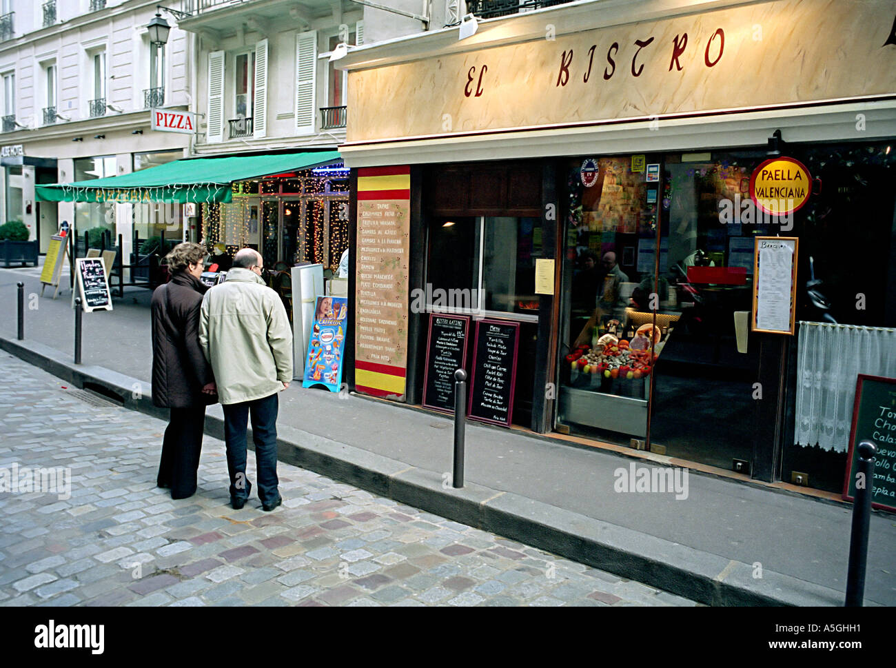 Un couple vérifie le menu d'un restaurant dans le quartier Saint Mishel une populaire destination touristique à Paris Banque D'Images