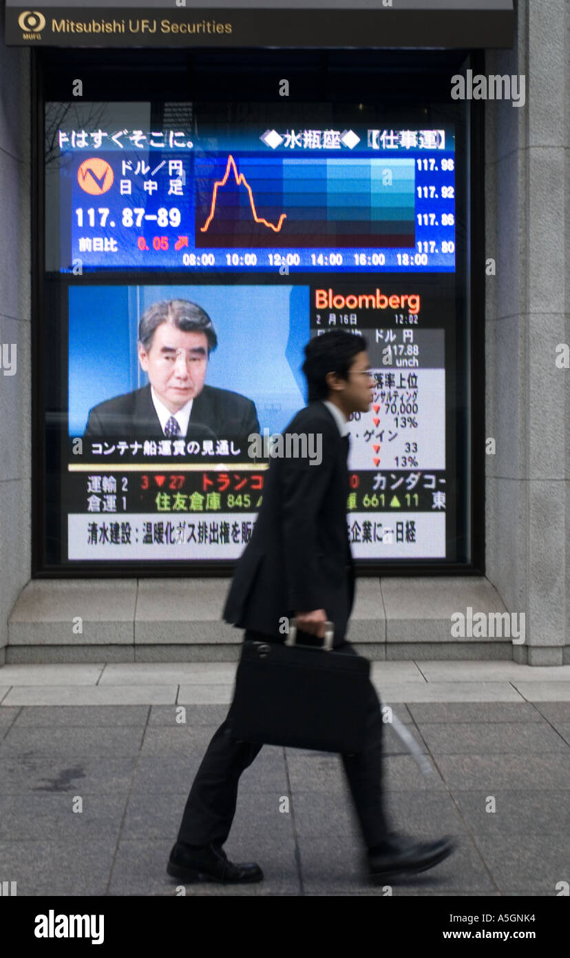 L'homme passe devant l'écran de télévision montrant des nouvelles de marché boursier à Tokyo au Japon Banque D'Images
