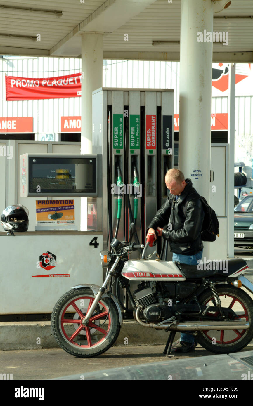 Remplissage du moteur à essence au cycliste de station-service Banque D'Images