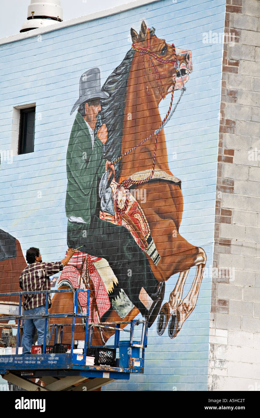 Chicago Illinois mâles adultes peinture murale extérieure mexicaine sur l'édifice de brique à l'aide d'ascenseur quartier Pilsen Banque D'Images