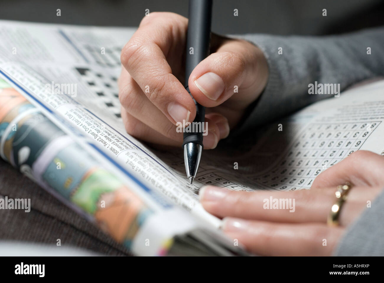 Femme de mots croisés dans les journaux Banque D'Images