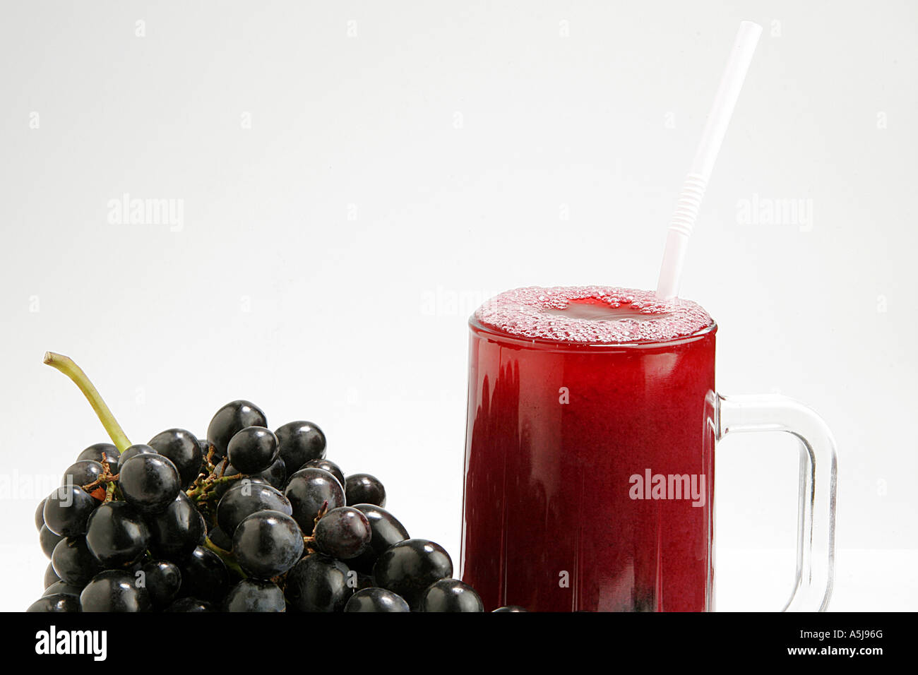 Les raisins noirs Fruits Jus de verre fond blanc Banque D'Images