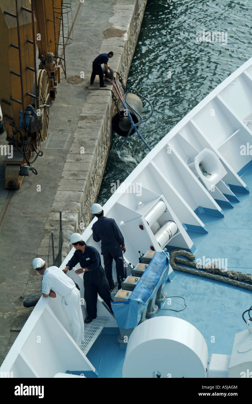 Bateau de croisière de passage de pont avant officier chargé de superviser la coordination de l'équipage docker glisser amarre lourd au départ de Tarragone Espagne Port Banque D'Images