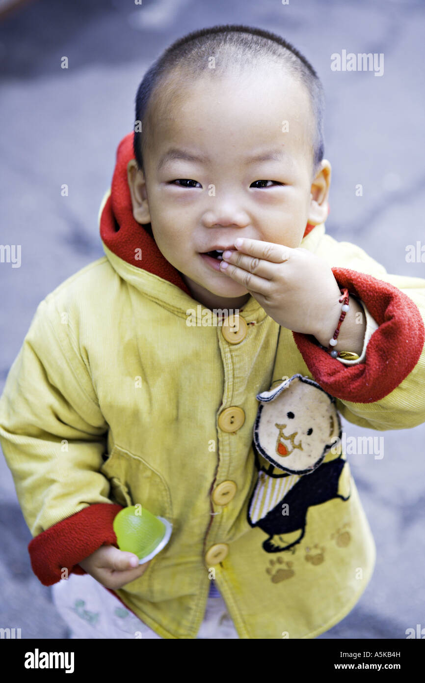 Chine SHANGHAI Jeune garçon chinois tout-petit dans une veste rouge et  jaune vif souffle un baiser Photo Stock - Alamy