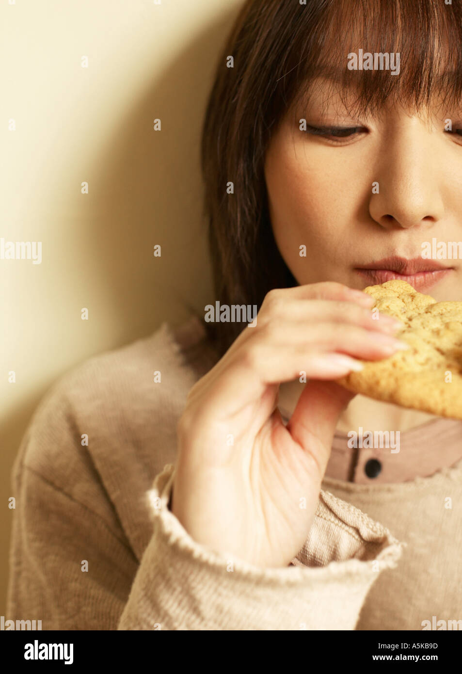 Young woman eating cookie Banque D'Images