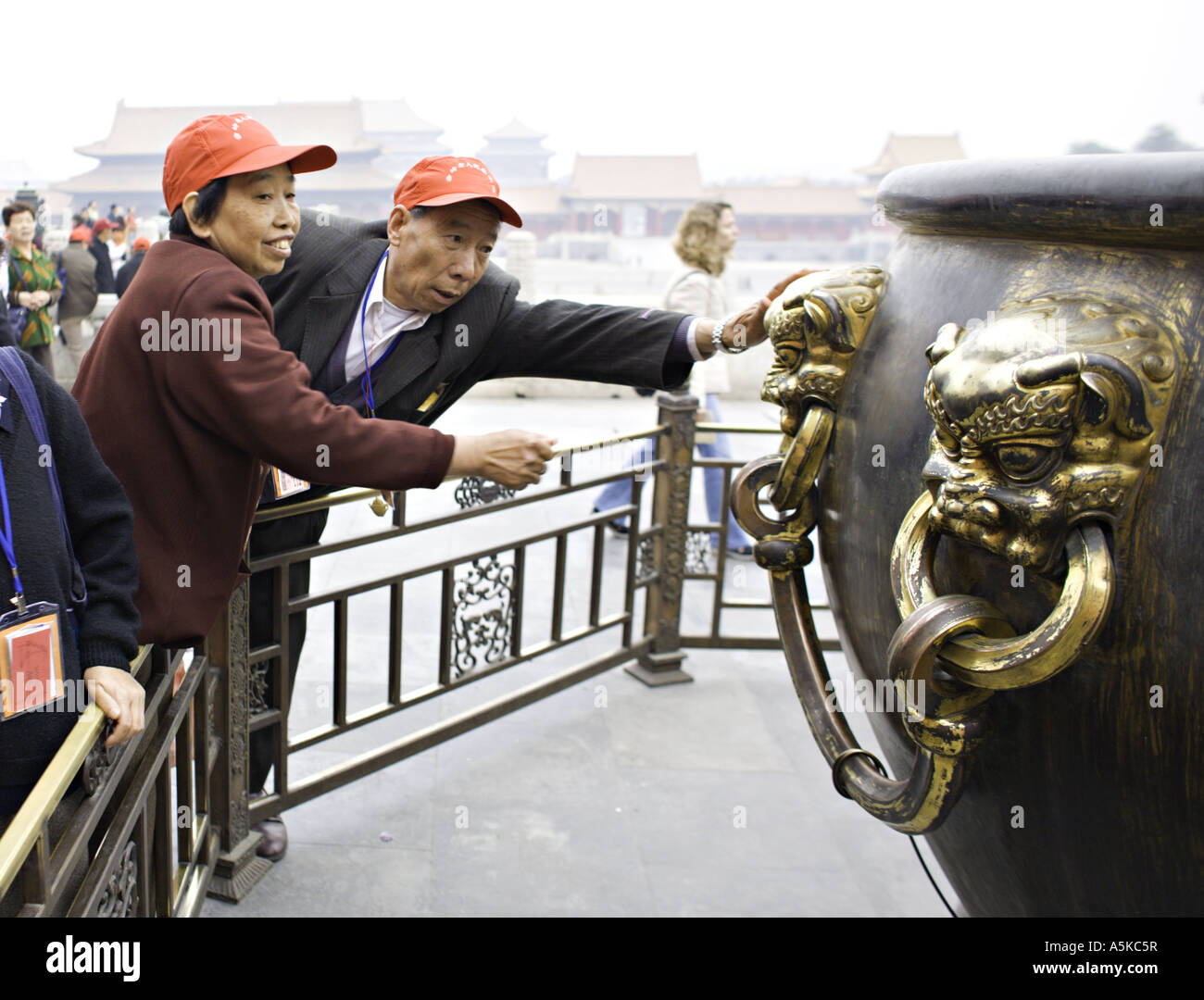 BEIJING CHINE groupe de voyageurs chinois portant des casquettes de  baseball frotte pour la bonne chance les lions en laiton sur un énorme pot  Photo Stock - Alamy