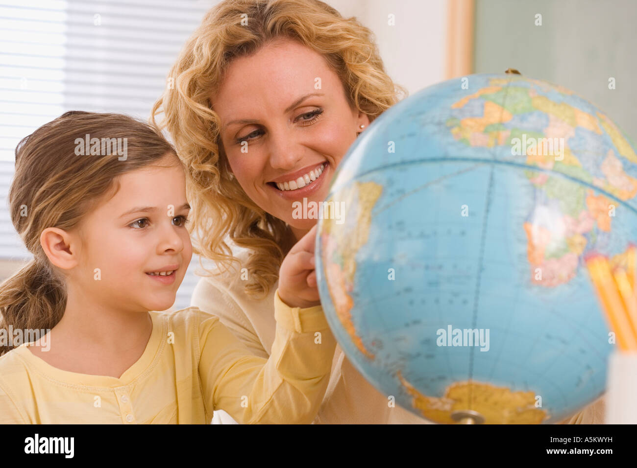 Mère et fille looking at globe Banque D'Images