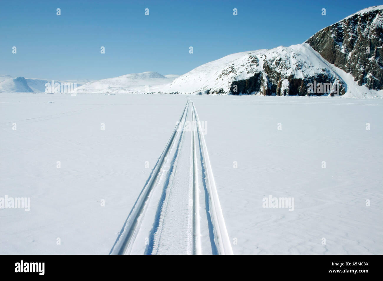 Des pistes de motoneige traversent la glace de mer douce près de la communauté inuite de Qikitarjuaq, au Nunavut, dans l'Arctique canadien Banque D'Images
