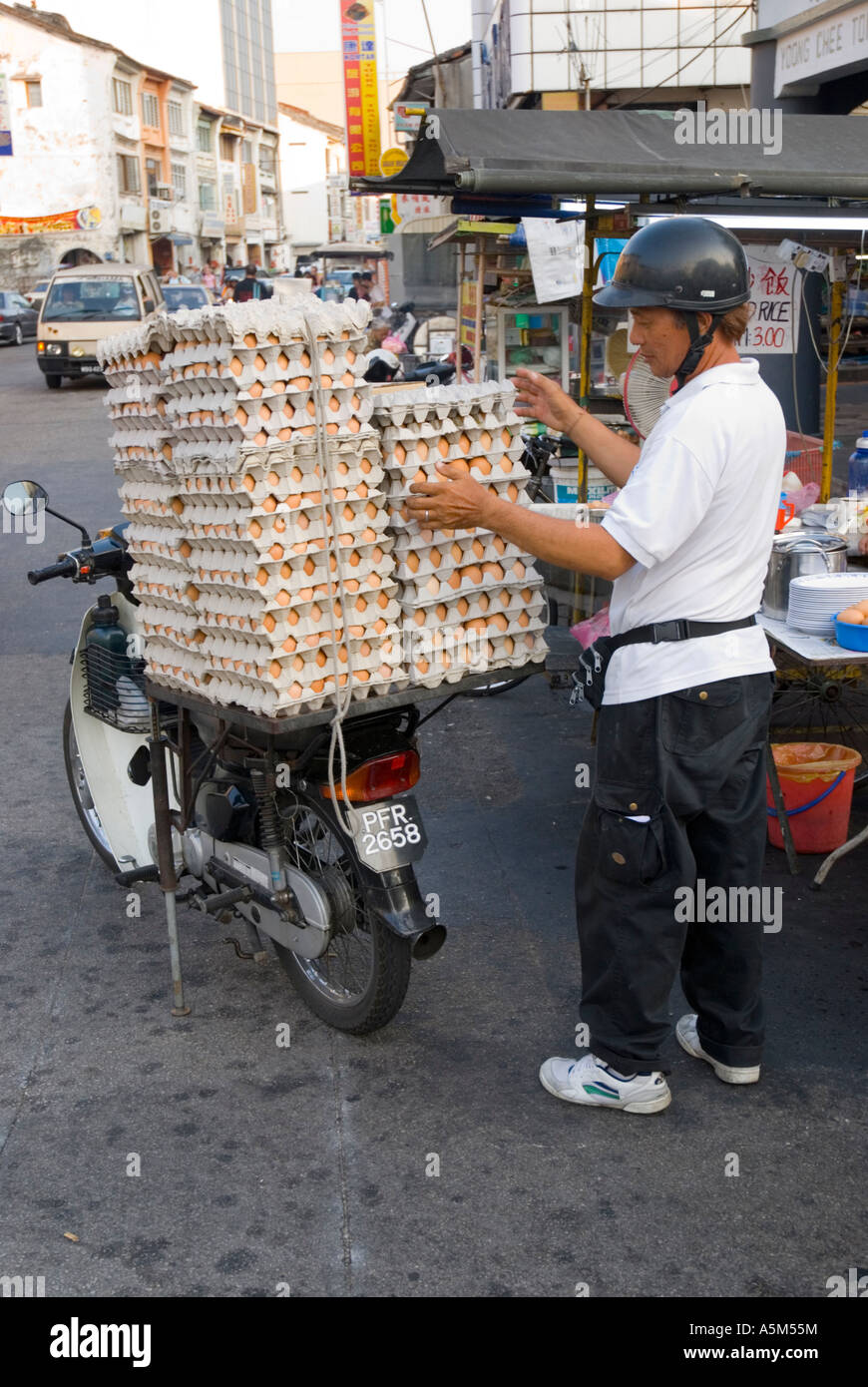 Homme livrant des oeufs par moto pour les restaurants à Georgetown Penang Malaisie Banque D'Images