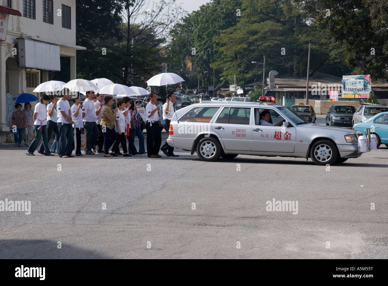 Un cortège funéraire chinois marchant derrière un corbillard à Ipoh Malaisie Banque D'Images