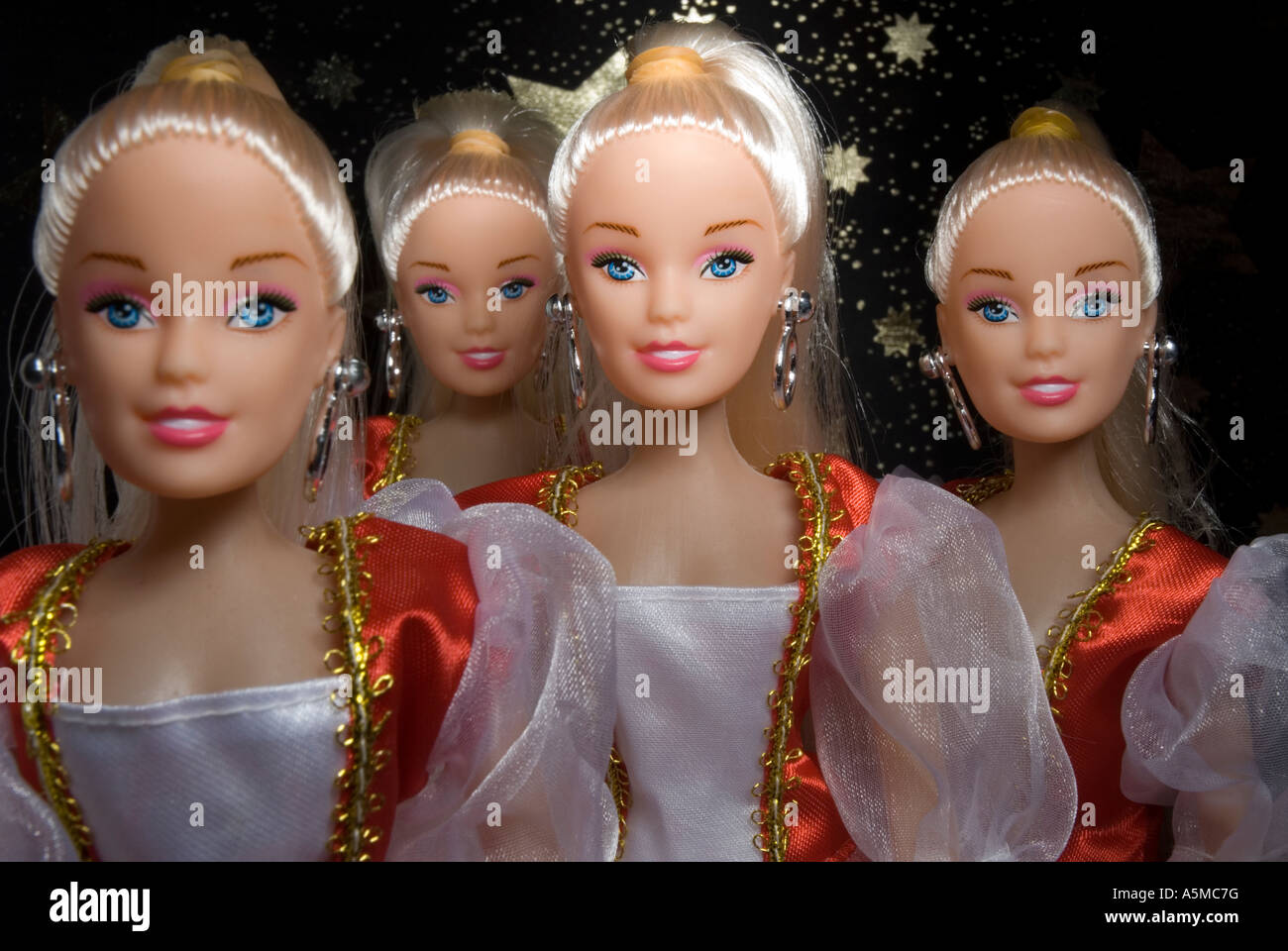 Quatre poupées en tenue de soirée noire contre un fond étoilé Banque D'Images