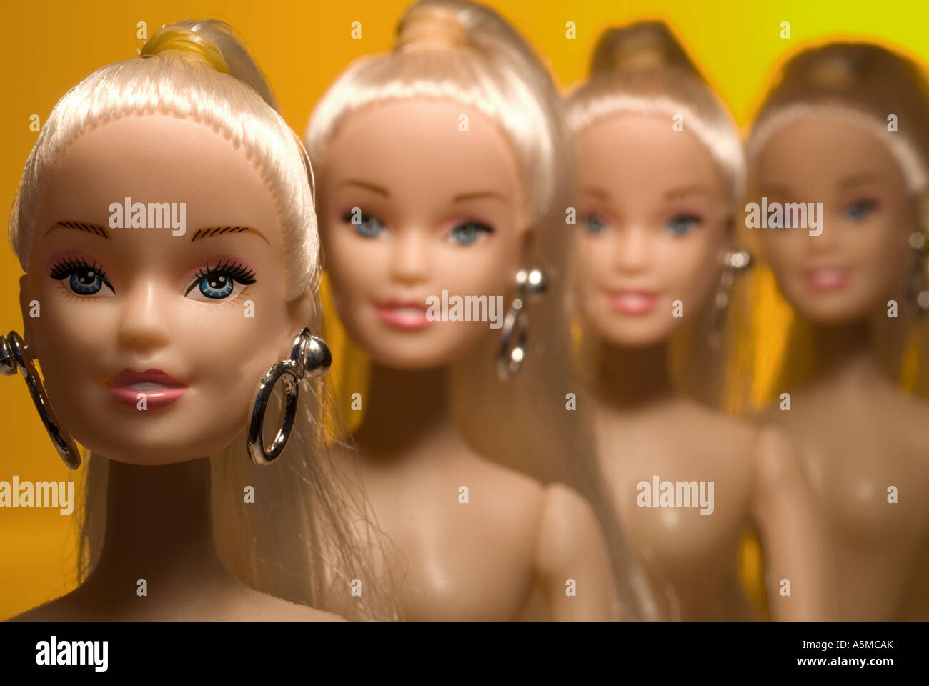 Quatre poupées de la tête et des épaules à l'arrière-plan orange jaune grad l'accent sur le milieu Banque D'Images