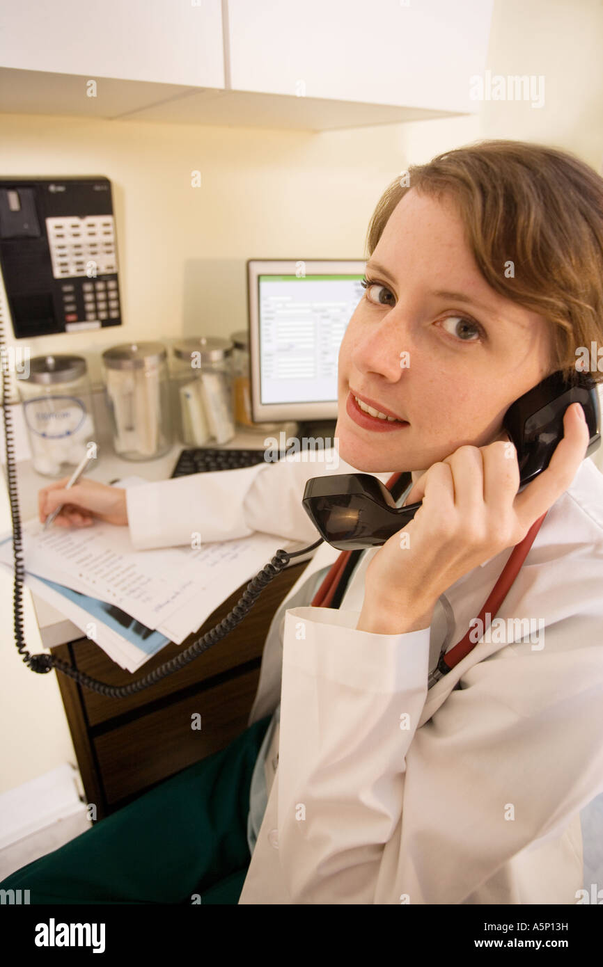 Médecin sur son téléphone de parler à un autre médecin ou le patient, ou elle peut être la commande de fournitures. Banque D'Images