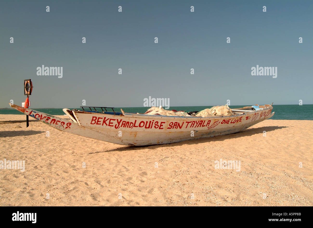 Bateau de pêche gambienne traditionnel sur la plage près de la Sénégambie Kololi Gambie Afrique de l'Ouest Banque D'Images