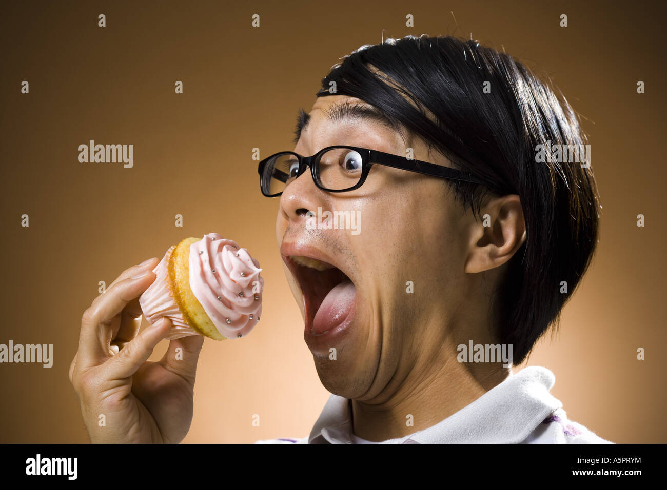 Man eating a cupcake Banque D'Images