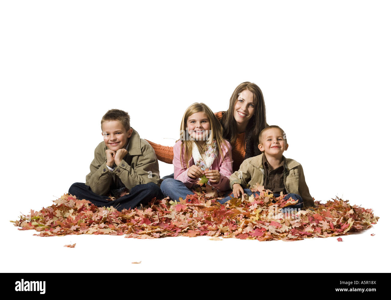 Family sitting in autumn leaves Banque D'Images