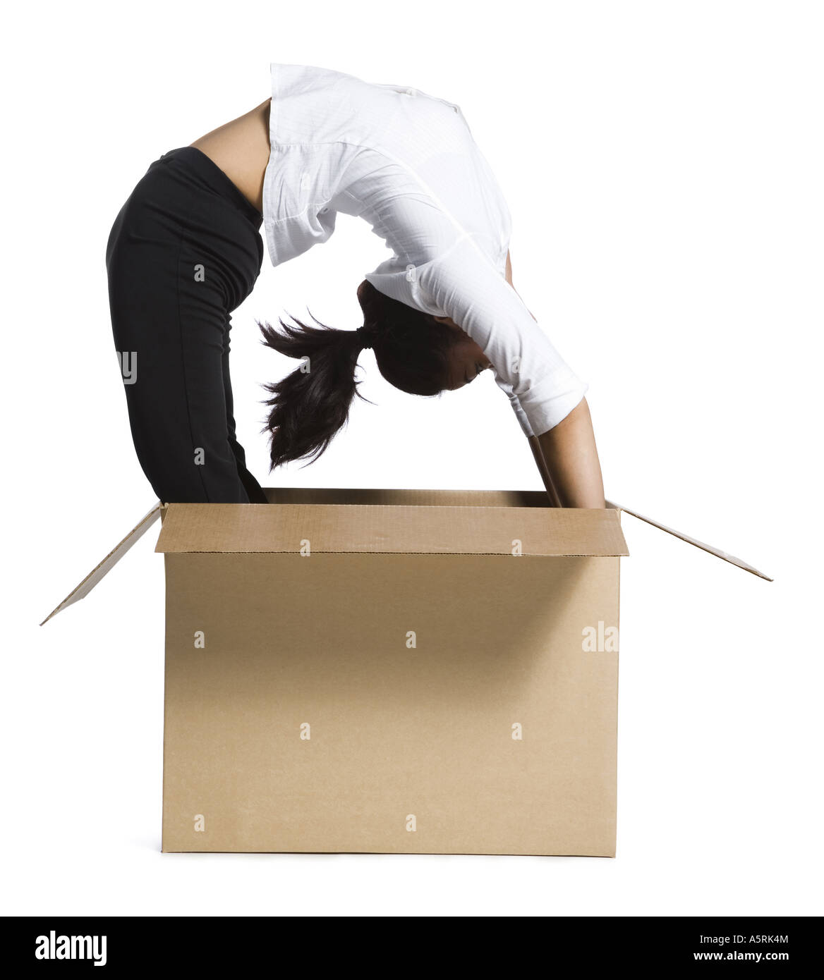 Female contortionist businesswoman inside cardboard box Banque D'Images