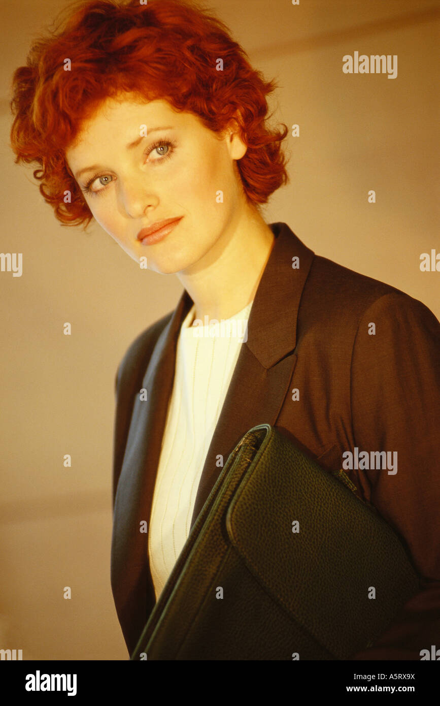 Businesswoman standing with briefcase underarm, portrait Banque D'Images