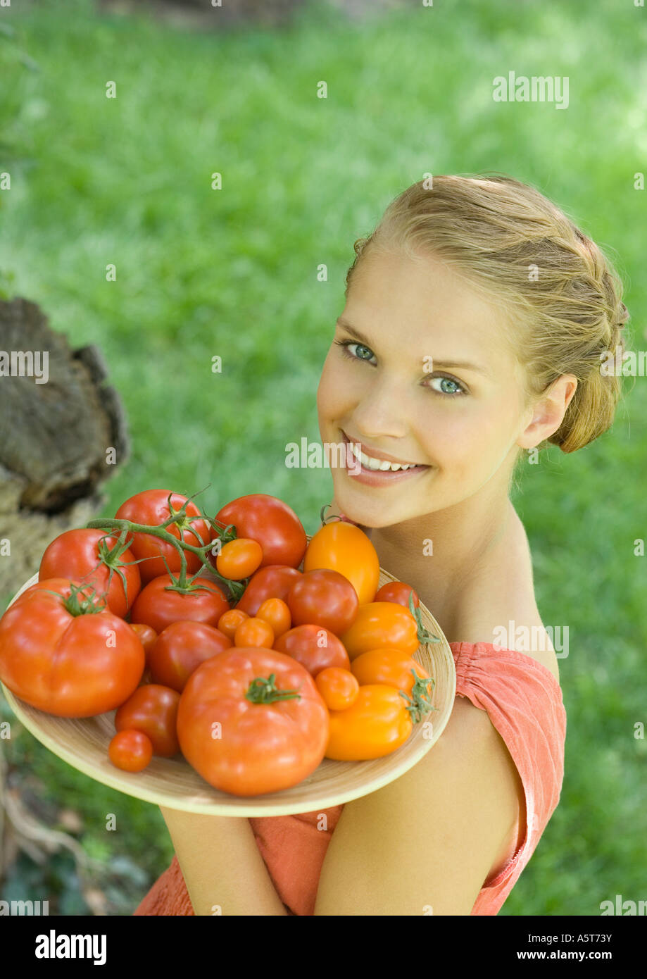 Woman holding bowl full of tomatoes Banque D'Images