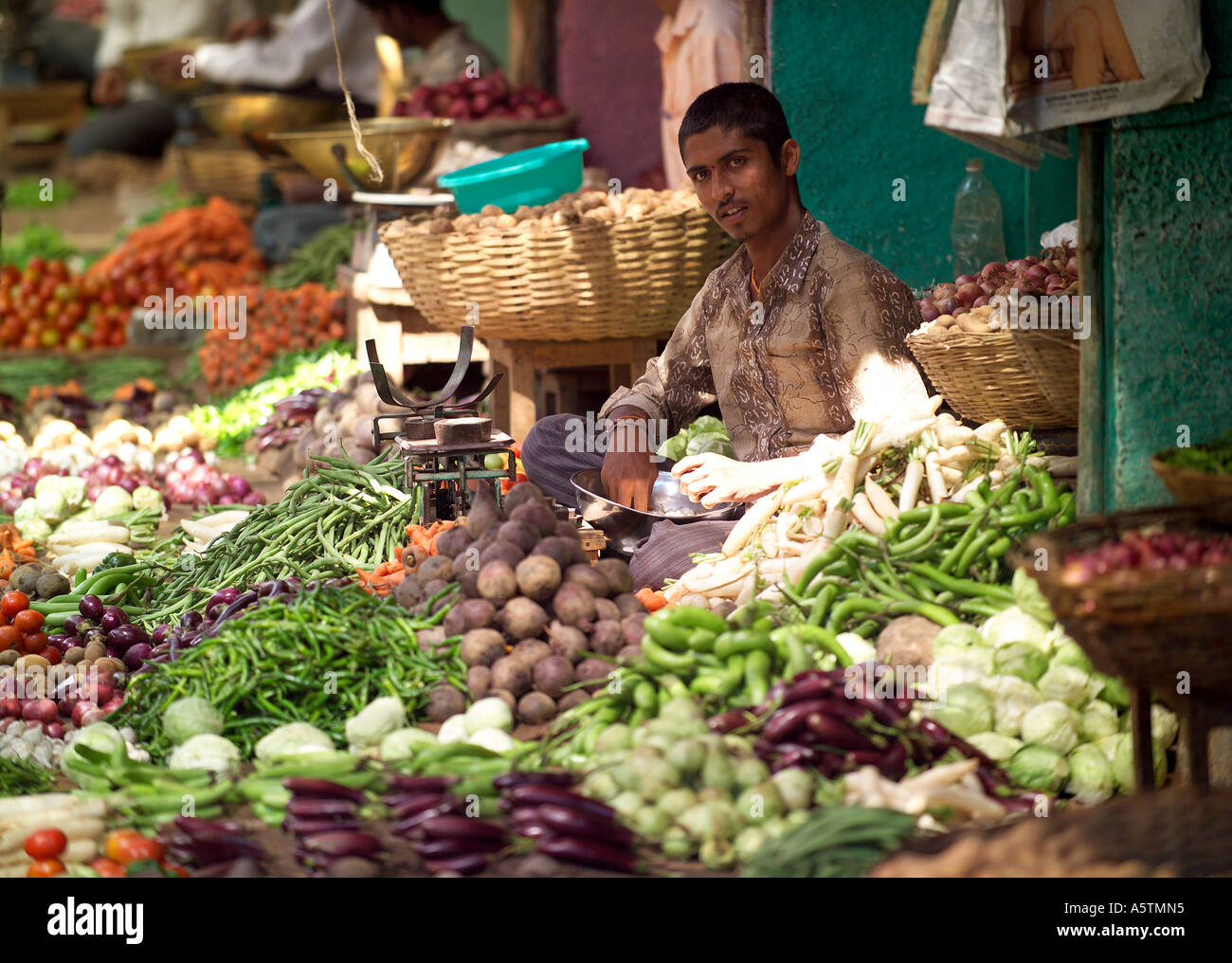 Jeune homme la vente de légumes, fruits et légumes du marché Devaraja, Mysore, Inde. Banque D'Images