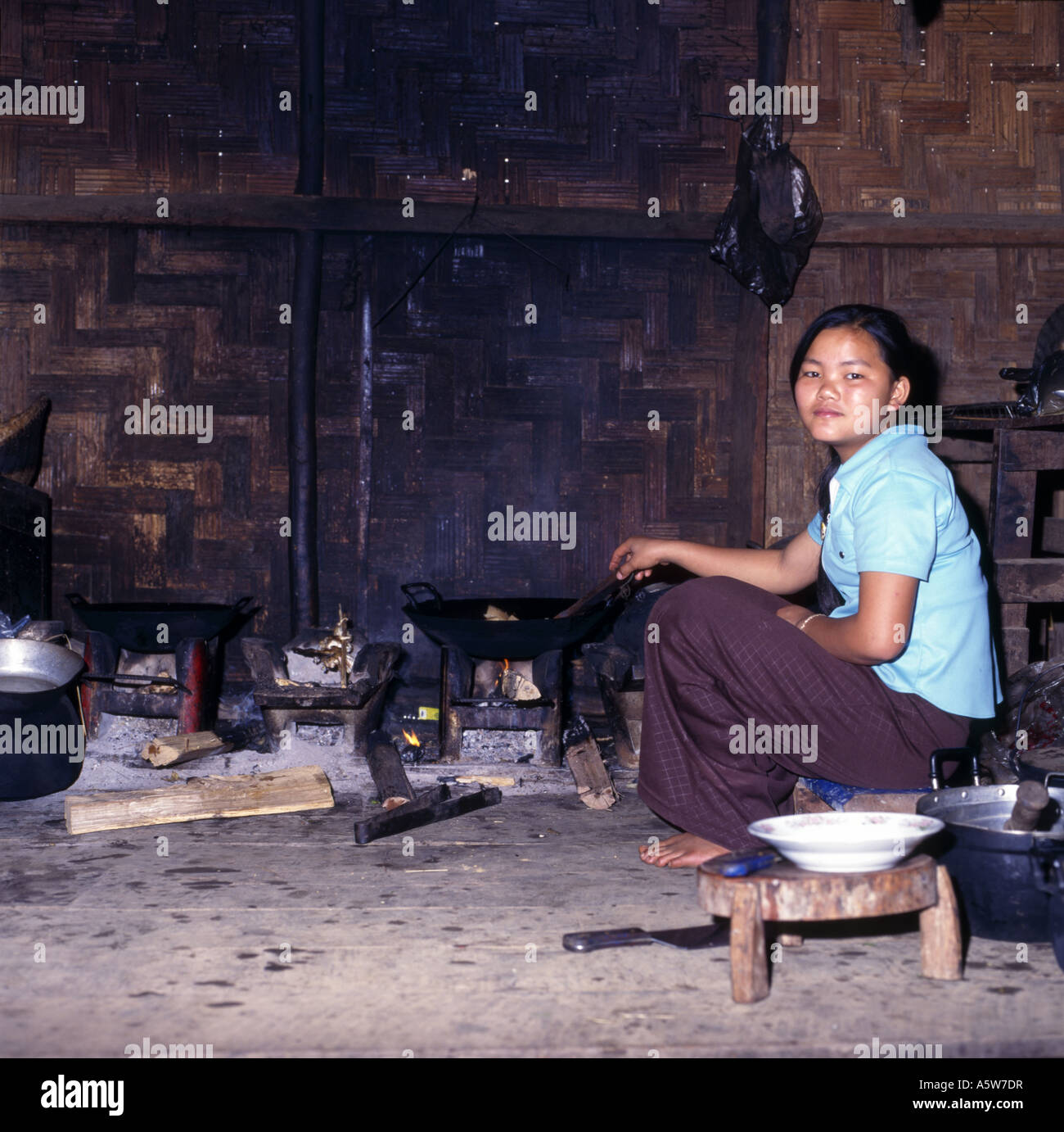Femme locale la cuisson à feu ouvert dans la cuisine traditionnelle,petit village rural du nord,le Laos. Banque D'Images