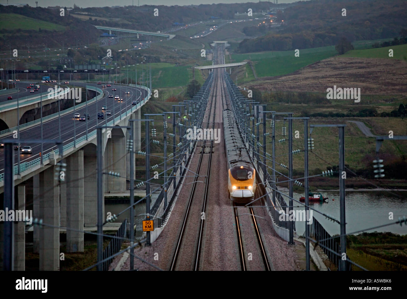 Train Eurostar traversant la rivière Medway de nuit à proximité de l'autoroute M2 sur une grande vitesse (Channel Tunnel Rail Link). Banque D'Images