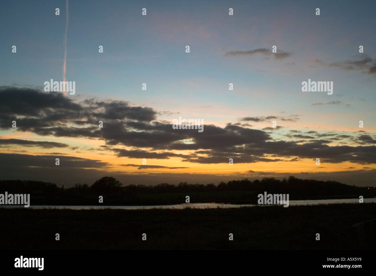 Sentier de l'avion dans le ciel et le coucher du soleil Banque D'Images