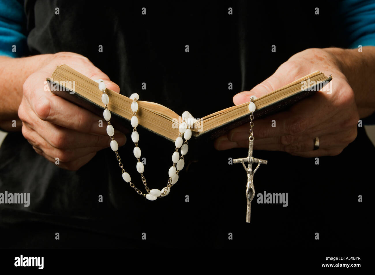 A woman's hand holding rosary et un livre de prières en priant Banque D'Images