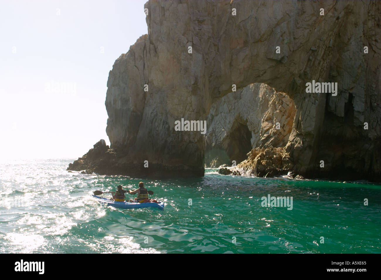 Mexique Cabo San Lucas Couple pagaie en kayak de mer vers El Arco arch creusé dans la roche de l'Océan Pacifique Banque D'Images