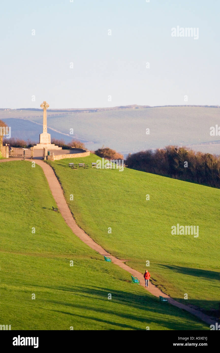 Femme en robe rouge en descendant la colline de l'Padstow memorial. Tôt le matin. Cornouailles du nord. UK. Banque D'Images
