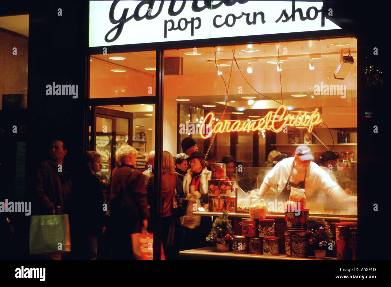 Nuit Chicago Illinois Garretts popcorn shop sur Michigan Avenue, les clients en ligne homme écope de maïs au caramel Banque D'Images
