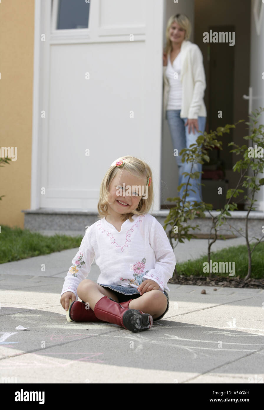 Petite fille assise sur le sol de la mère Banque D'Images