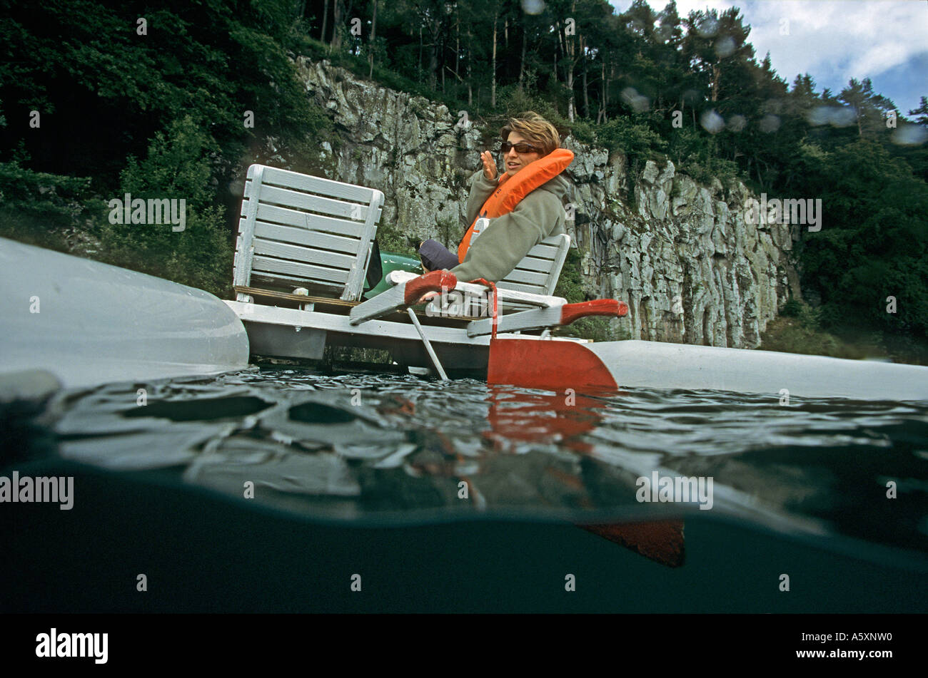 Vue d'une jeune femme sur un pédalo. Lac Pavin (France). Vue mi-air mi-eau d'une jeune femme sur un pédalo (France). Banque D'Images