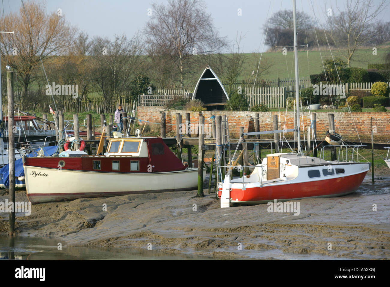 Pris dans la boue des bateaux à marée basse, St Osyth, Essex, Angleterre, RU Banque D'Images