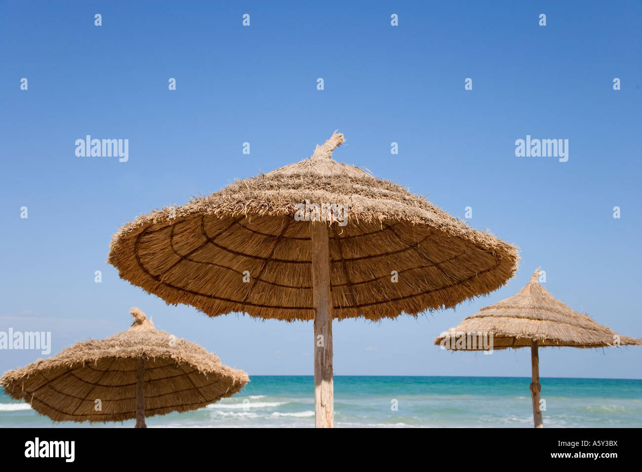 Trois des parasols en paille sur la plage à Djerba Tunisie Photo Stock -  Alamy