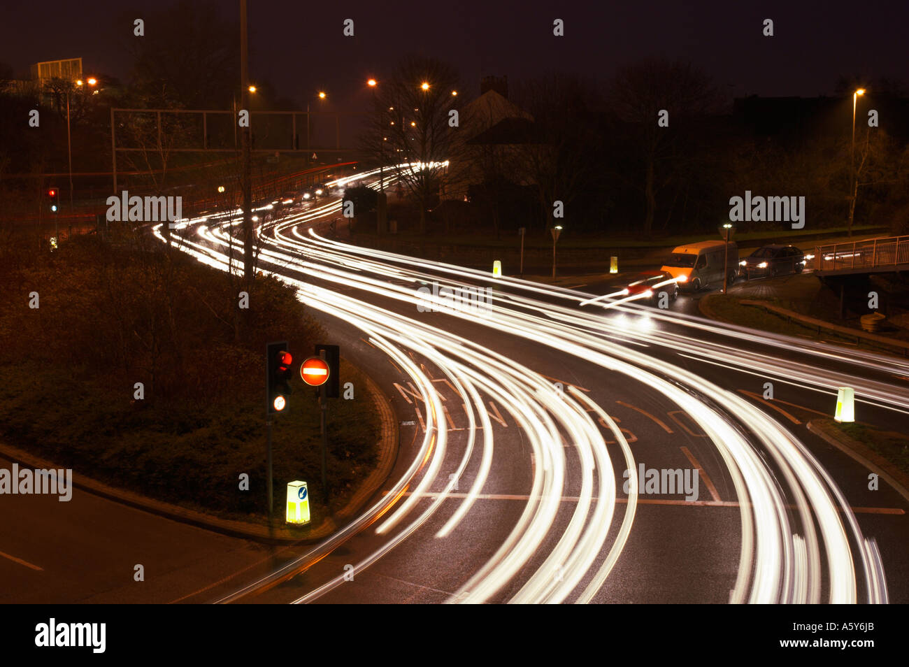 Des sentiers de lumière causé par le trafic d'une route très fréquentée à l'intersection avec feux de circulation England UK Banque D'Images Des sentiers de lumière causé par le trafic d'une route très fréquentée à l'intersection avec feux de circulation England UK Banque D'Images