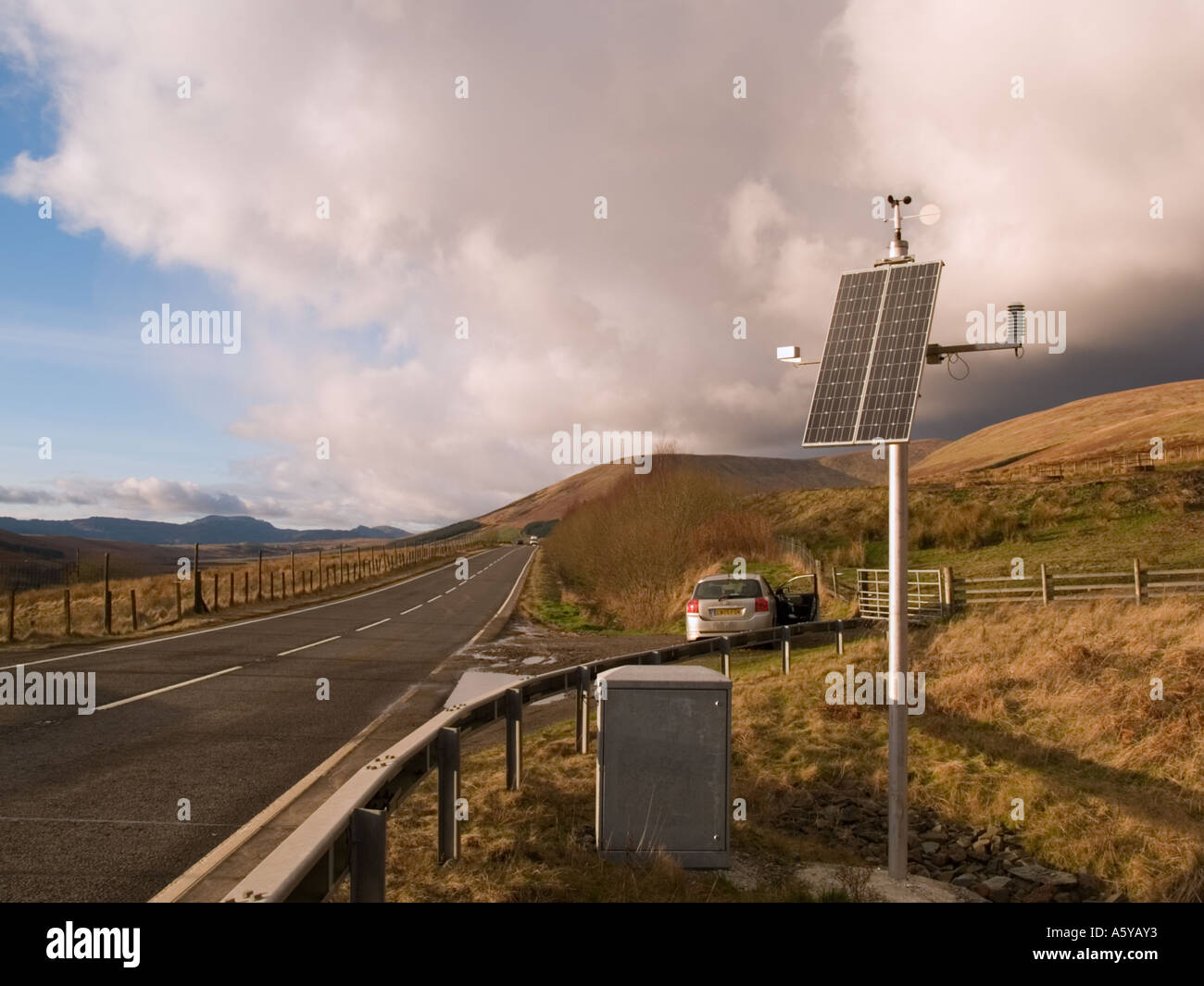 STATION Météo à énergie solaire à côté de route en hiver soleil contre la colère du ciel sombre. Bute Argyll Scotland UK Banque D'Images