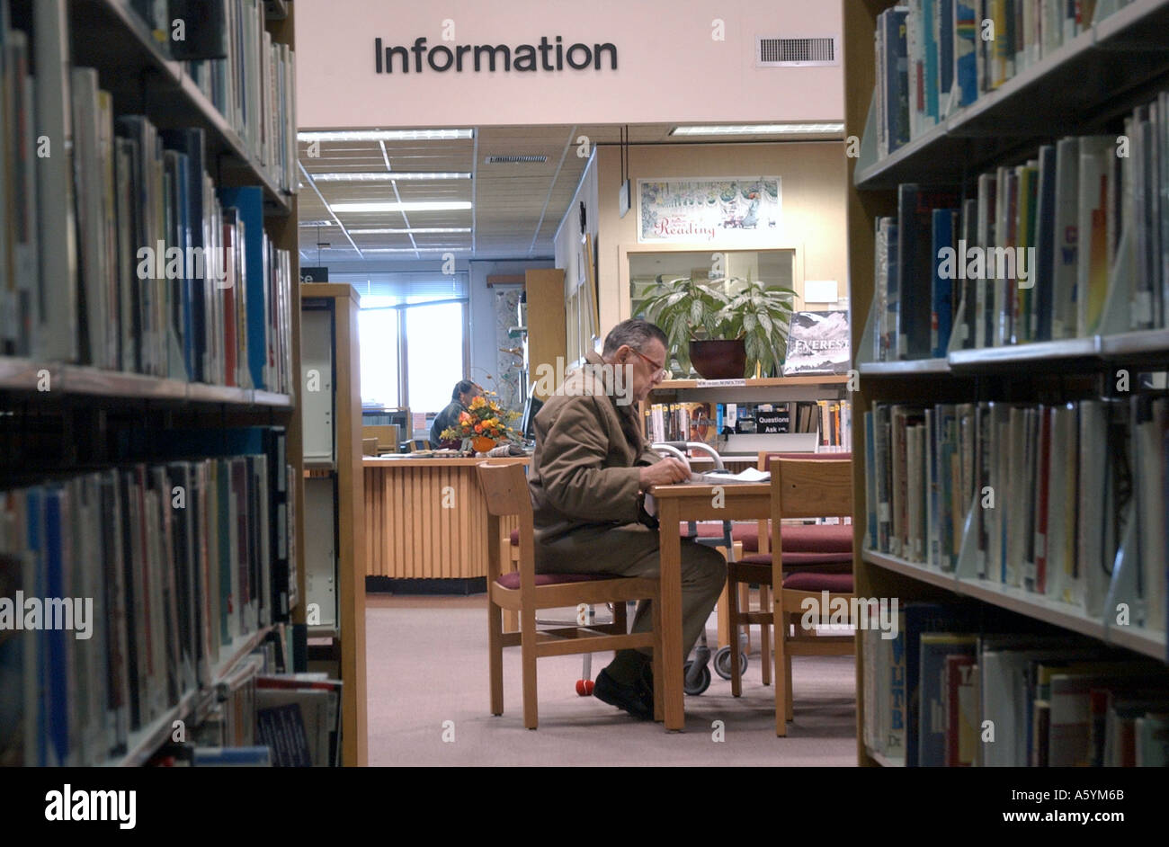 Un homme lisant le journal dans une bibliothèque Banque D'Images