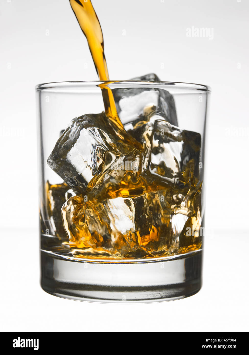 Verser le whisky sur les glaçons dans le verre Tumbler Banque D'Images
