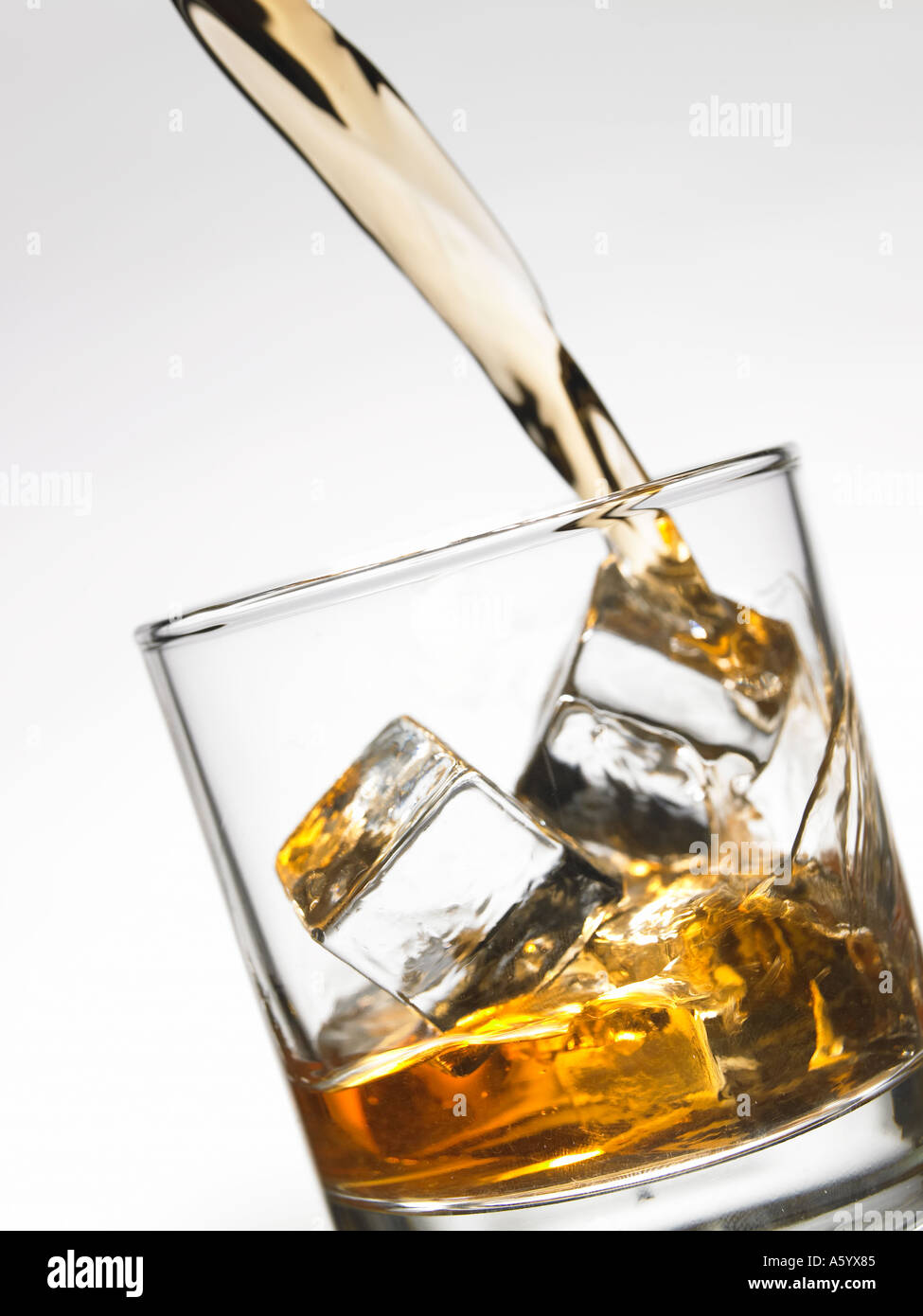 Verser le whisky sur les glaçons dans le verre Tumbler Banque D'Images