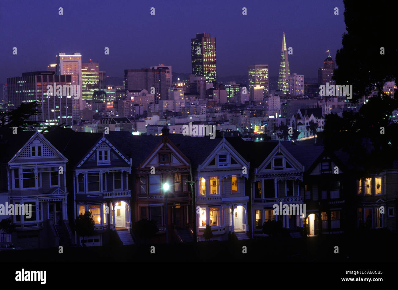 La Californie San Francisco soir vue de carte postale maisons victoriennes de rangs sur Alamo Square et le centre-ville Banque D'Images