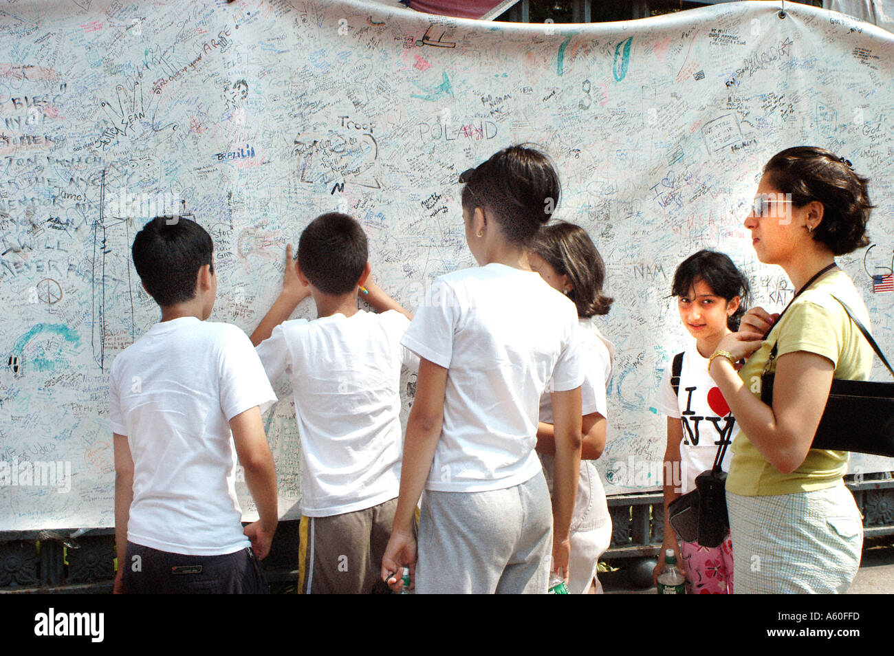 NEW YORK, NY, USA, Groupe de touristes adolescents, Signing in message Board at Memorial Quilt pour 9/11 près de 'Ground Zero', étudiants de derrière Banque D'Images