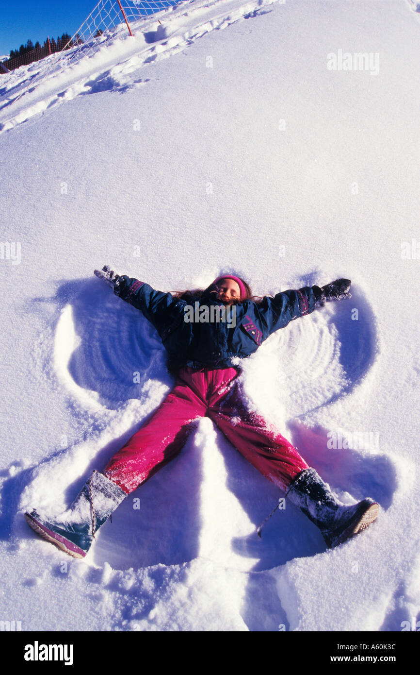 Une jeune fille de 10 ans fait un ange de neige dans la neige fraîche de Crested Butte Colorado USA Banque D'Images