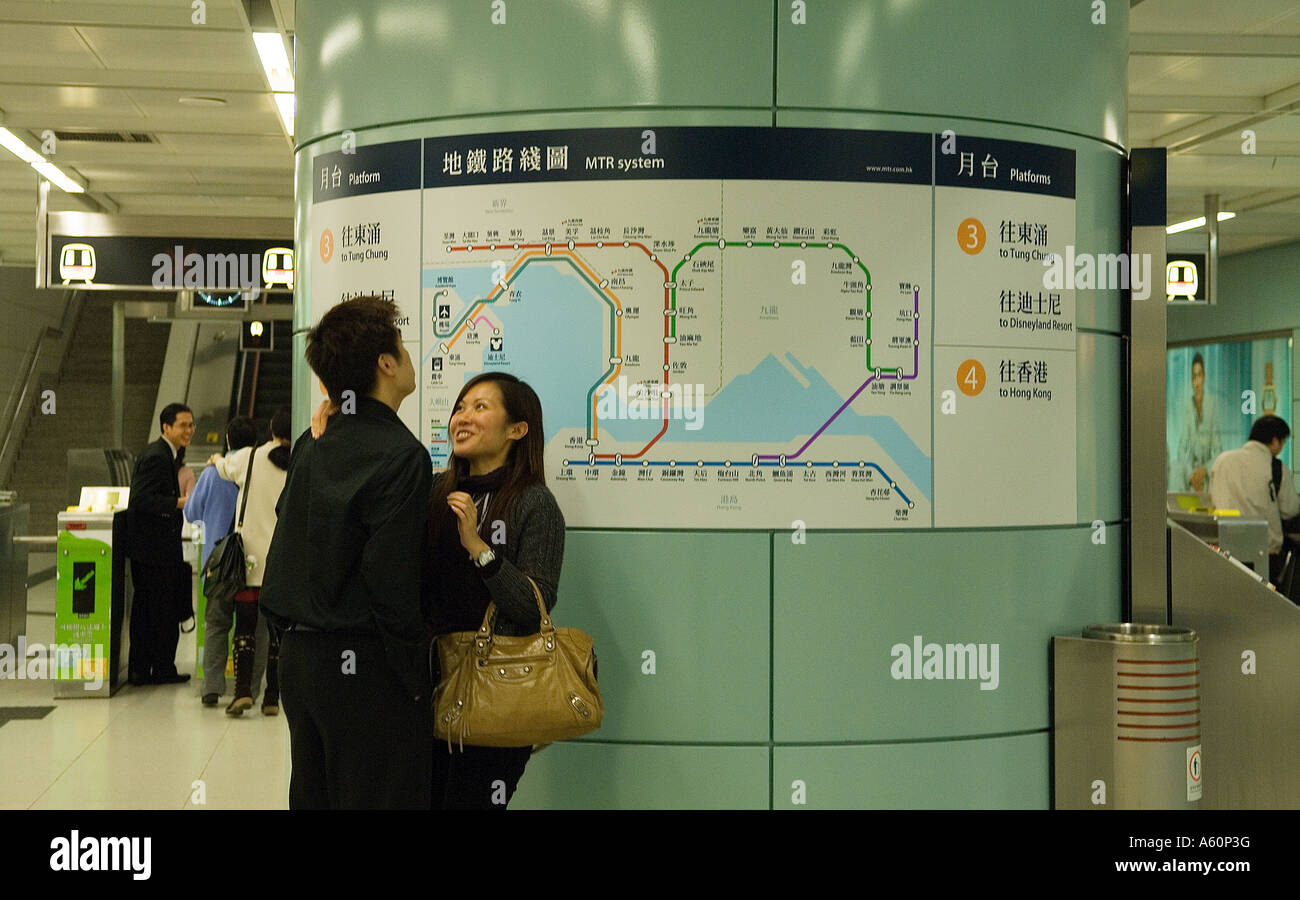 La gare de métro MTR plate-forme système de Hong Kong, Chine. Jeune couple en face de transport ferroviaire souterrain route planner map Banque D'Images