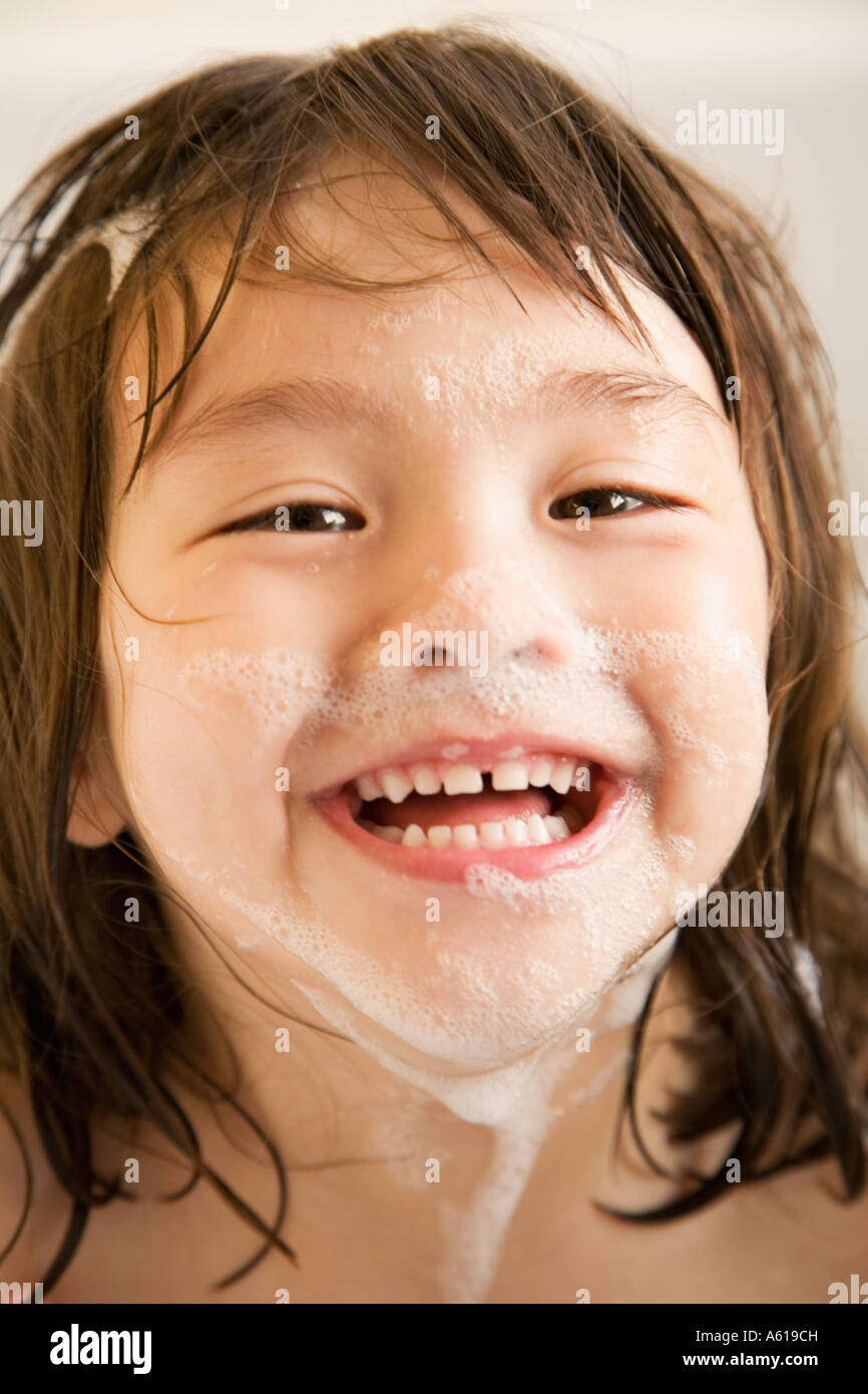Fille asiatique avec de l'eau savonneuse sur le visage Banque D'Images