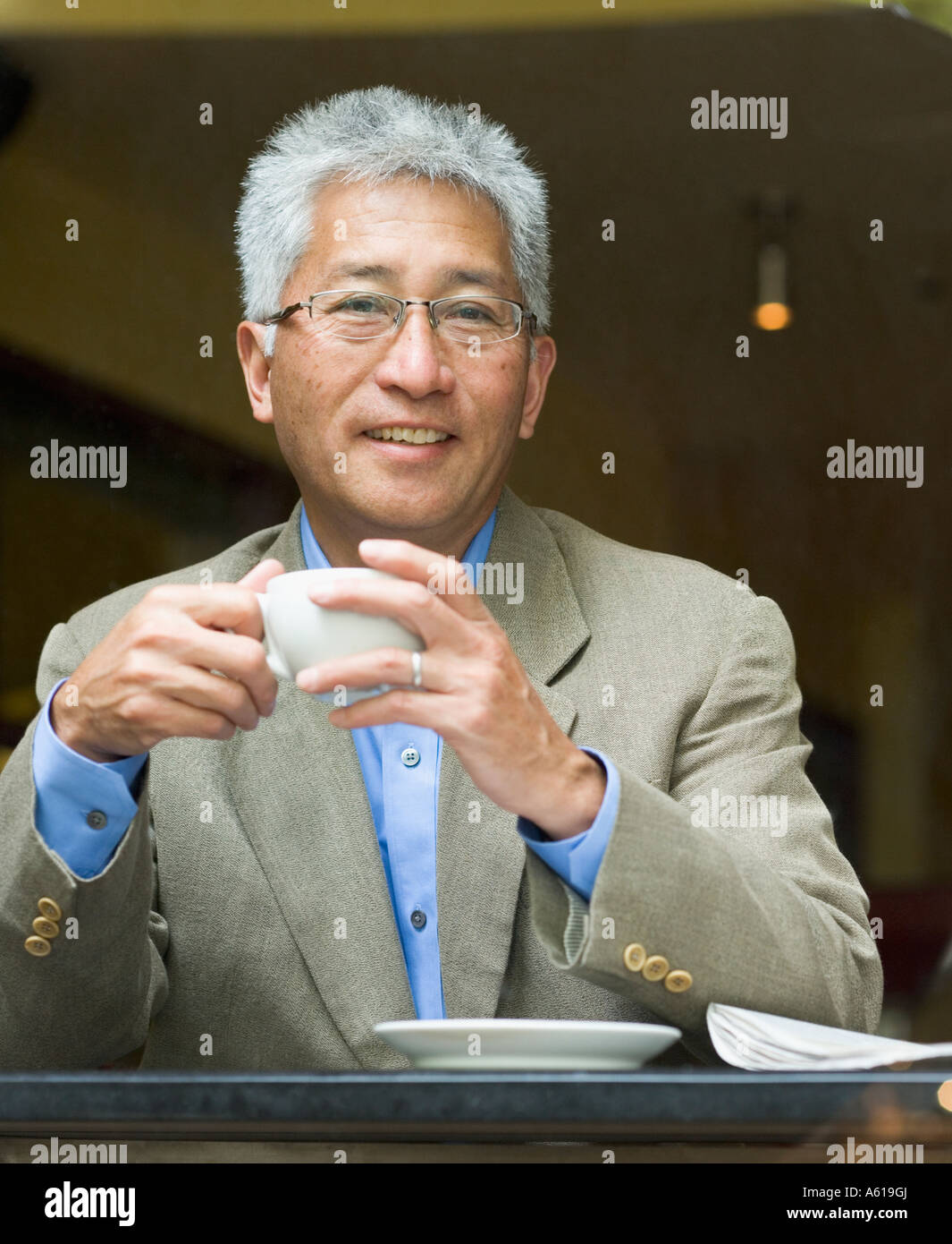 Senior Asian businessman holding tasse de café Banque D'Images