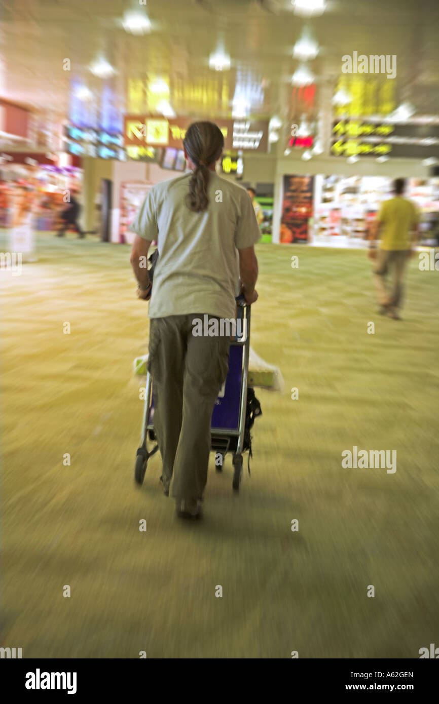 Man pushing trolley grâce à l'aéroport de Changi, Singapour Banque D'Images