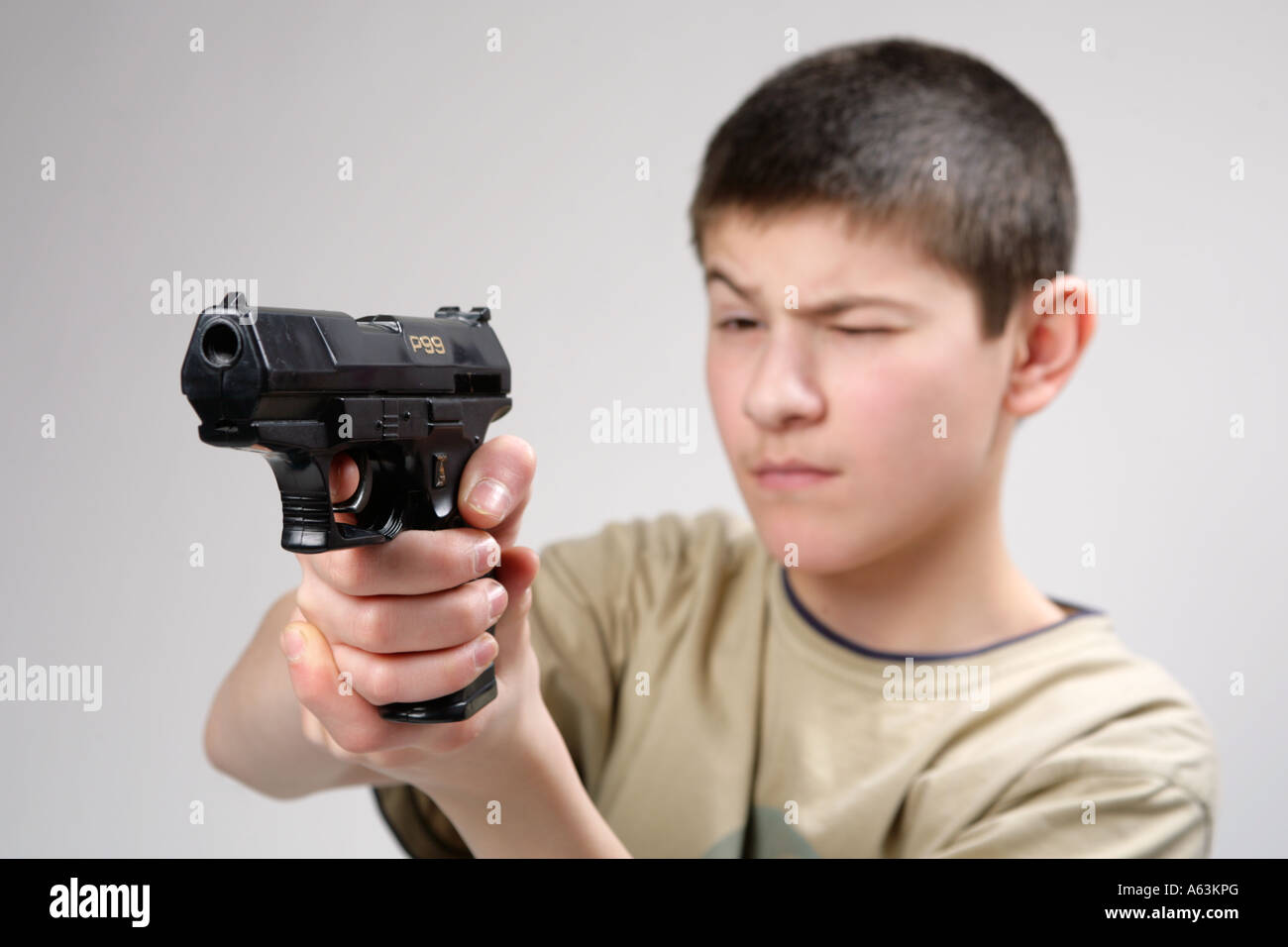 Jeune garçon pointant son pistolet jouet à un ennemi caché Photo Stock -  Alamy
