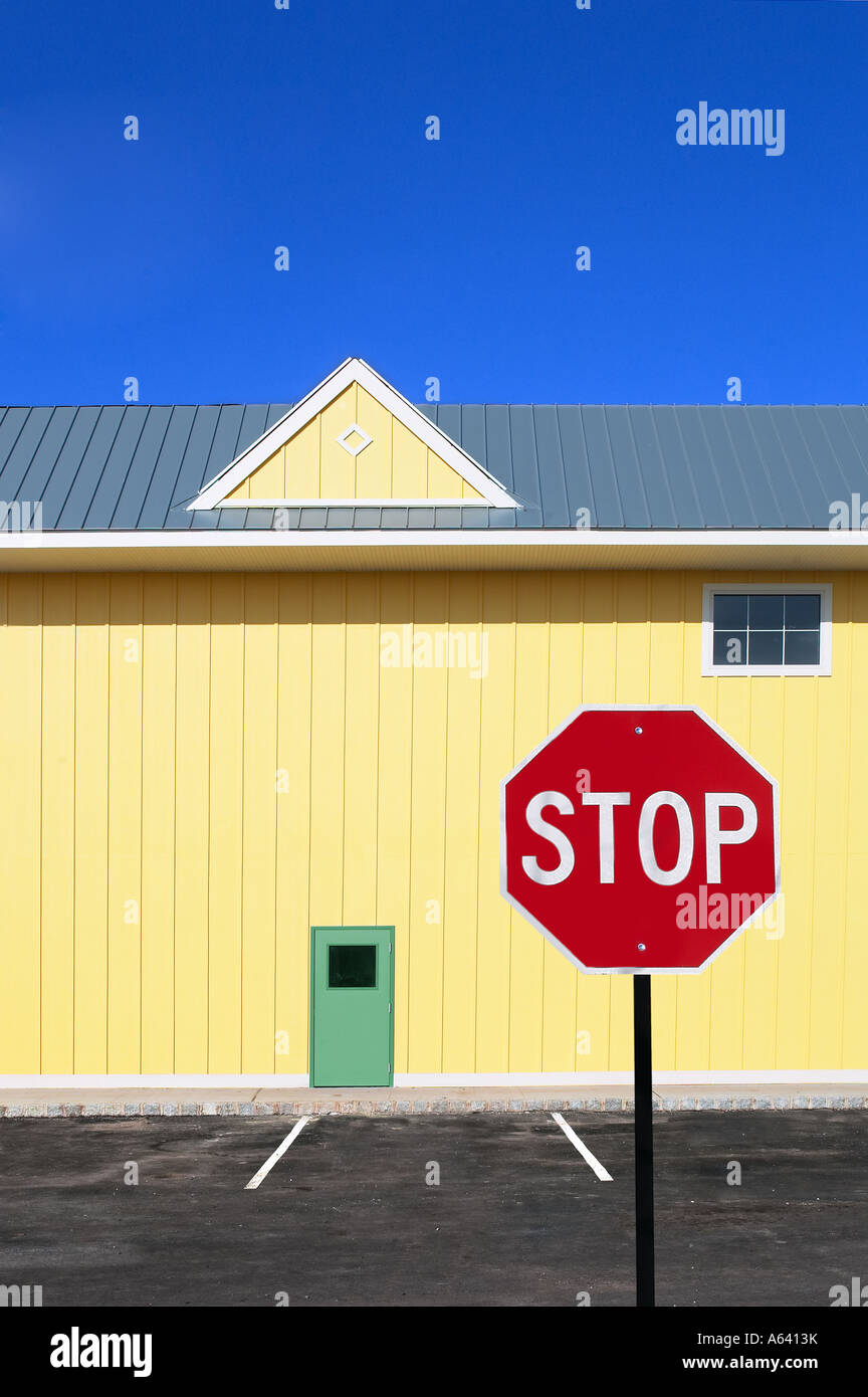 Graphic bâtiment jaune avec signe de la circulation d'arrêt rouge, USA Banque D'Images